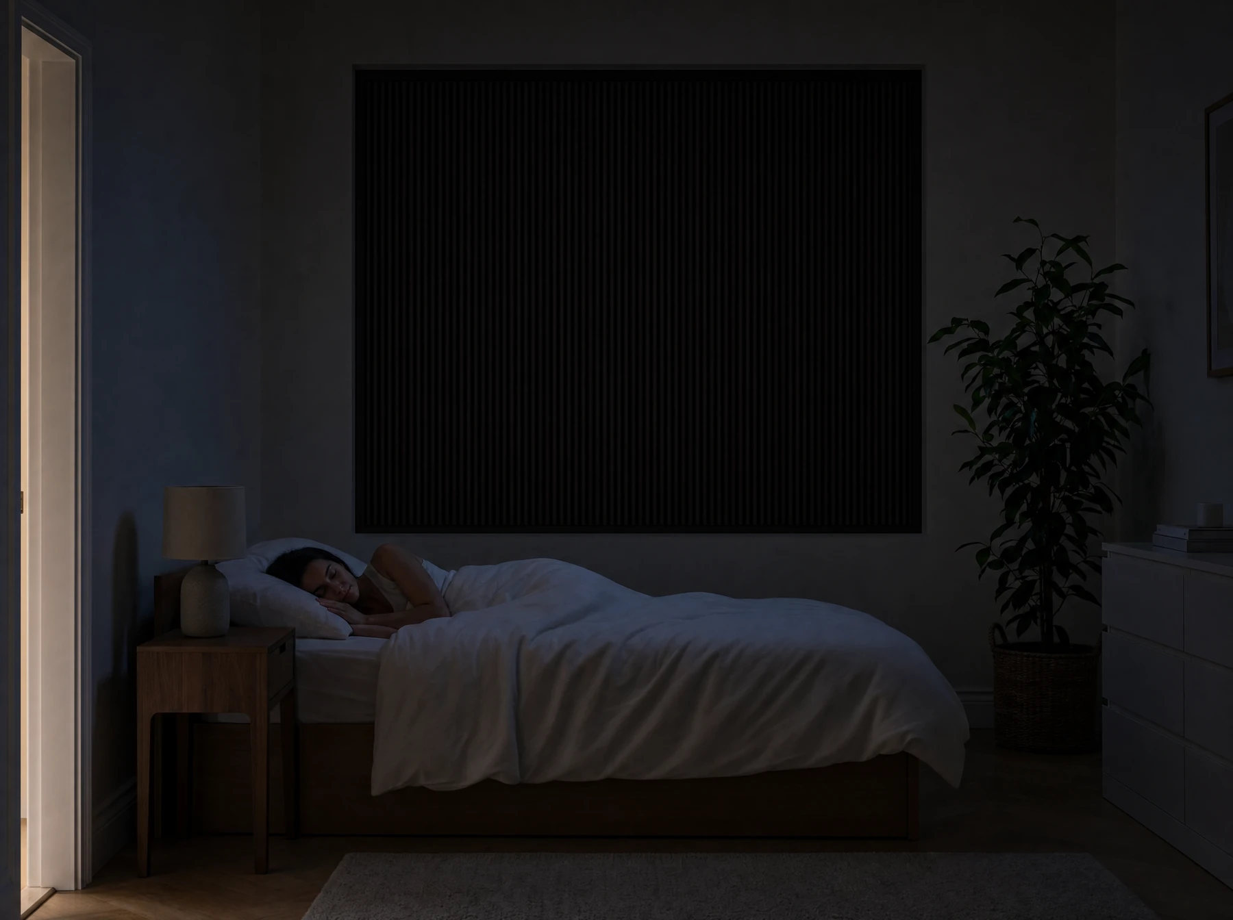 A dark bedroom with a OneRest blackout blind fitted to the window