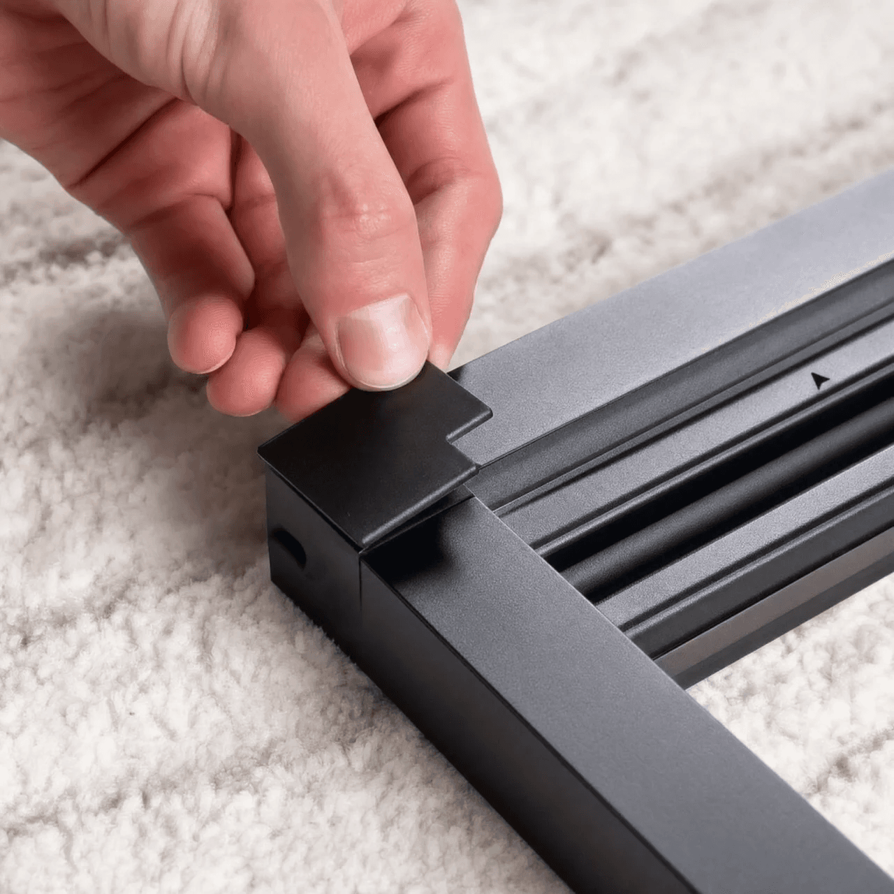 A person placing an assembled OneRest blackout blind inside a window recess