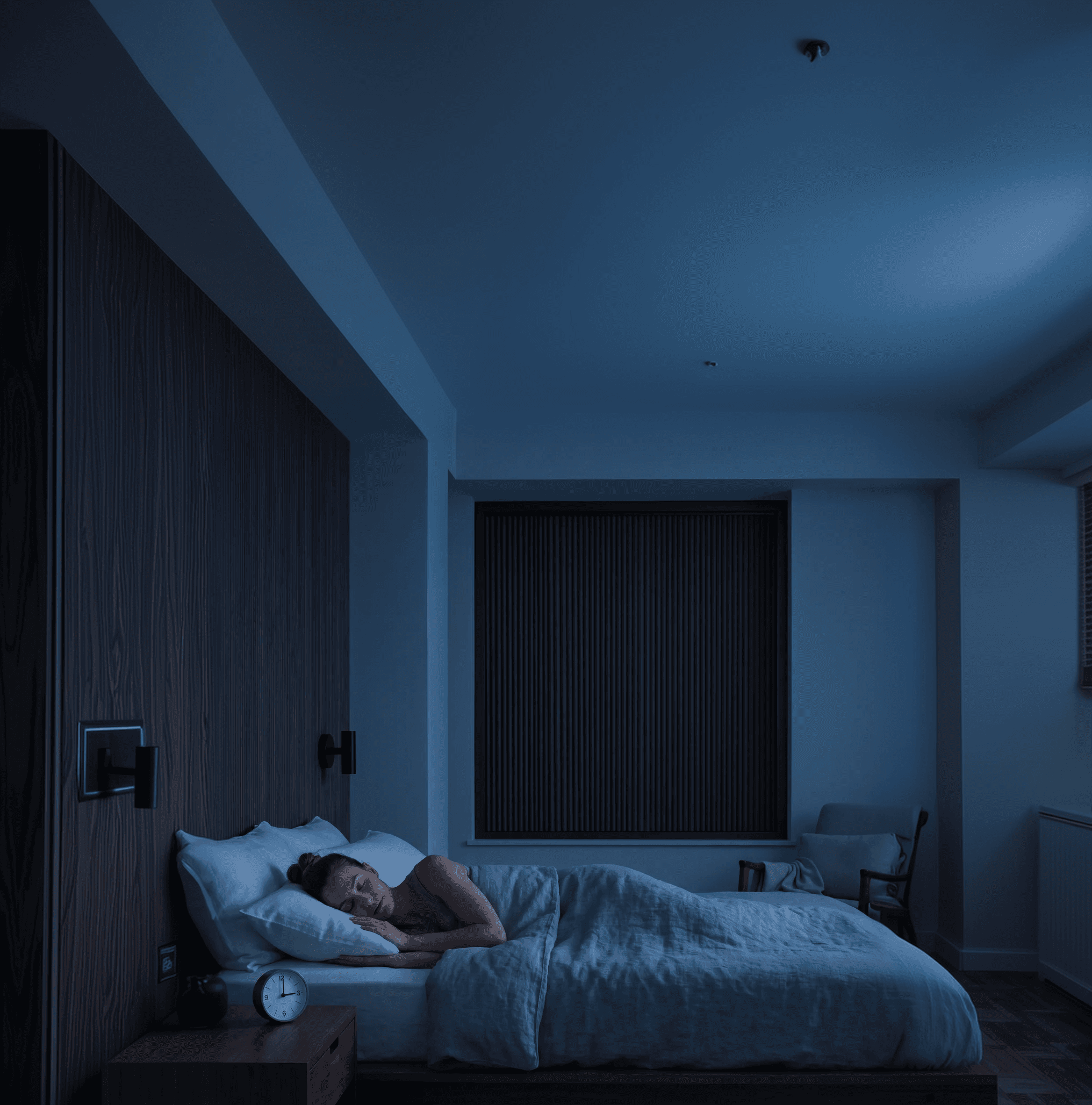 A dark bedroom with a OneRest blackout blind fitted to the window